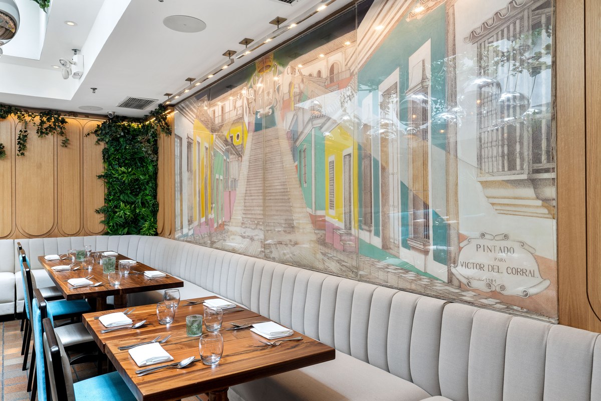 Tables beside the Cuban streetscape mural in the Havana Room